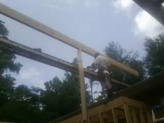 Carpenter setting a ridge beam over a new addition frame — Ice Dam Removal by Roofing Brothers in Nokomis