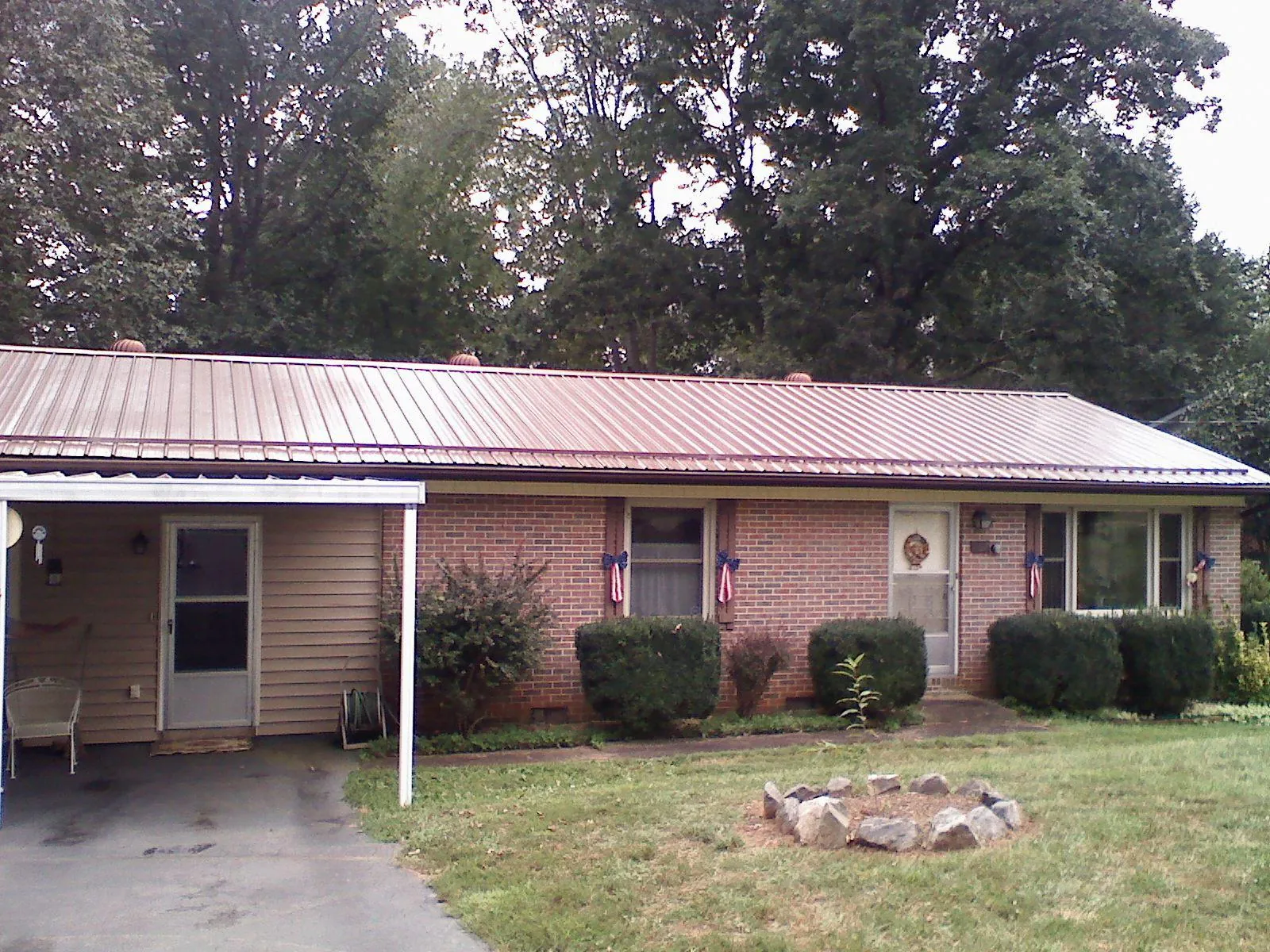 Bronze metal roof and carport on a brick ranch home — Roof Repair work by our crew in Nokomis